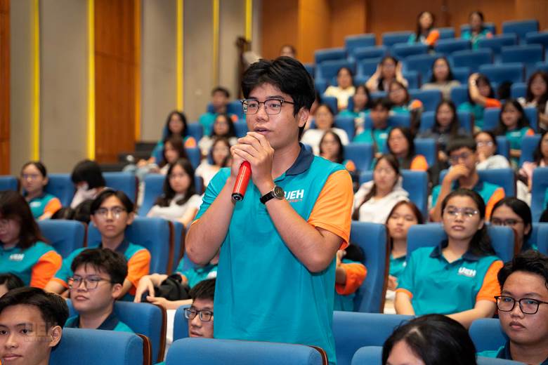 A person holding a microphone in front of a group of people
AI-generated content may be incorrect.