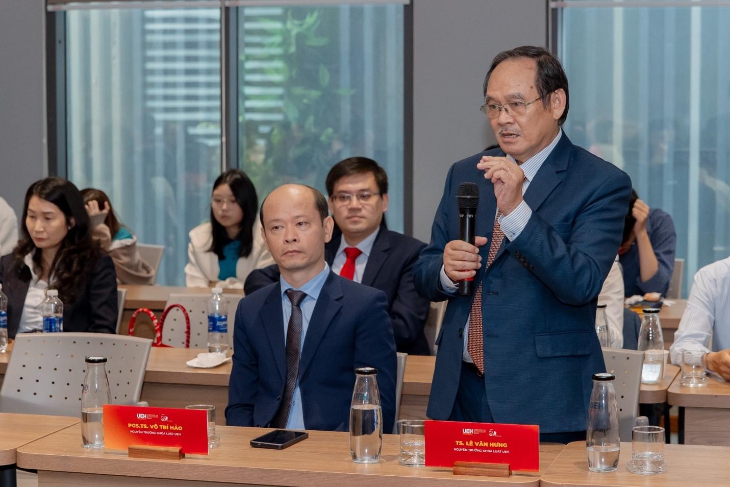 A person in a suit holding a microphone

AI-generated content may be incorrect.